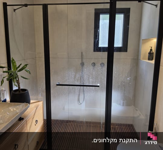 חדר אמבטיה עם מקלחון זכוכית ושירותים